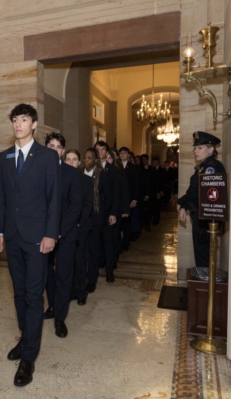 Students in navy suits walking through the historic Senate chamber hallway in Washington, D.C.